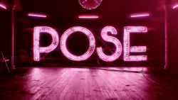 Logo for the television show POSE. In Pink neon letters, the word 'POSE' on a pink-lit stage, otherwise dark.